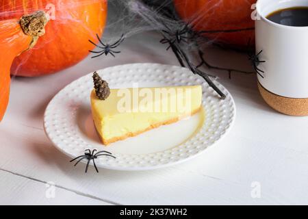 Halloween gâteries concept avec tarte à la citrouille, tasse de thé ou café décoré de citrouilles et araignées noires sur fond de bois blanc. Halloween gr Banque D'Images