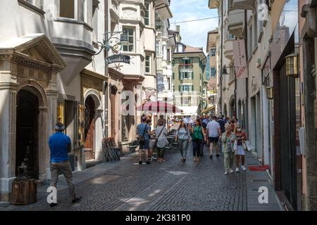 Diverses personnes dans une ancienne ruelle de la vieille ville de Bolzano en Italie. Banque D'Images