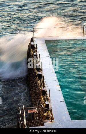 Piscine à côté de l'océan dans les tons chauds du lever du soleil à Sydney, Nouvelle-Galles du Sud, Australie Banque D'Images