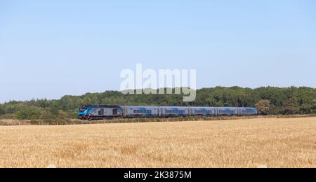 Premier train Transennine Express Nova 3 avec une locomotive de classe 68 passant devant des terres arables dans le Lincolnshire Banque D'Images