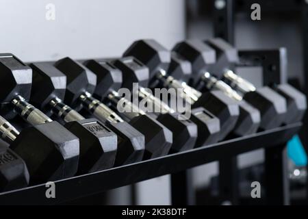 Dumbbbbell blurry maison salle de gym mur ensemble de stockage rig sport, concept accessoires équipement en gros plan et homme sain, muscle de forme. Levage , Banque D'Images