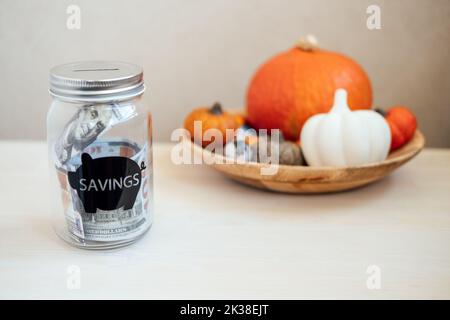 Économisez de l'argent idées pour le jour de Thanksgiving, économisez, Thanksgiving sur le budget. Pot de maçon en verre avec banque de piggy en argent sur la décoration de citrouille de Thanksgiving Banque D'Images