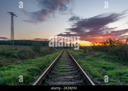 Ancienne voie ferrée non électrifiée près de la ville de Rakovnik en soirée couleur coucher de soleil Banque D'Images