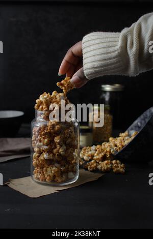 Une femme cuelait du pop-corn au caramel maison Banque D'Images