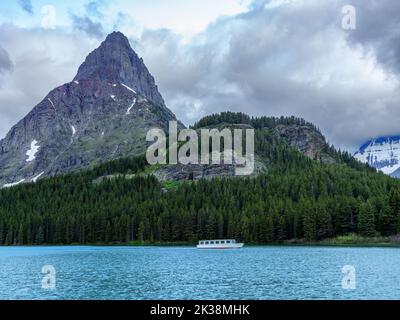 Le bateau flou de mouvement traverse un lac dans le parc national des Glaciers Banque D'Images