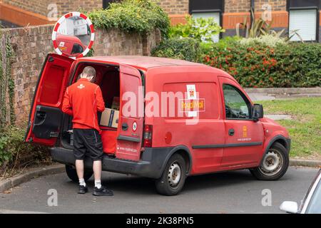 Royal Mail Group : camion de livraison rouge et homme de poste. Angleterre, Royaume-Uni. Concept - marque Royal Mail, service postal, collecte de courrier, livraison de colis Banque D'Images