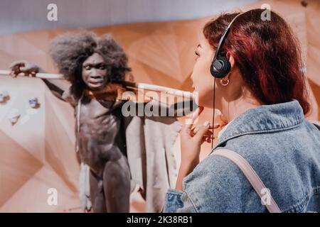 22 juillet 2022, Musée Néandertal, Allemagne : une fille écoute un audioguide avec écouteurs lors d'une visite du musée anthropologique. Banque D'Images