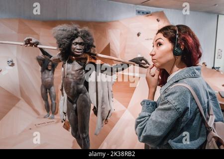 22 juillet 2022, Musée Néandertal, Allemagne : une fille écoute un audioguide avec écouteurs lors d'une visite du musée anthropologique. Banque D'Images