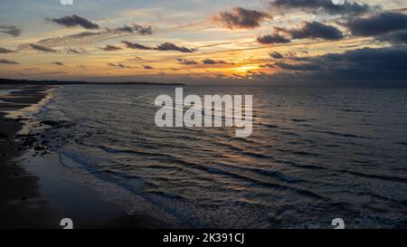 Vue fantastique sur le ciel sombre couvert. Spectaculaire et pittoresque coucher de soleil en soirée dorée sur la mer. Nuages de tempête, tempête passant au-dessus de la mer, nuages spectaculaires après la tempête au coucher du soleil. Défoqué. Photo de haute qualité Banque D'Images