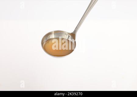 cuillère isolée sur fond blanc. bouillon de poulet sur cuillère. Banque D'Images