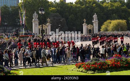 Des foules de touristes et de touristes qui regardent la bande des gardes en marchant Queen Victoria Monument et Buckingham Palace Londres Banque D'Images