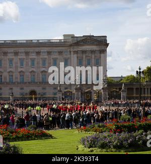 Des foules de touristes et de touristes qui regardent la bande des gardes en marchant Queen Victoria Monument et Buckingham Palace Londres Banque D'Images