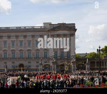 Des foules de touristes et de touristes qui regardent la bande des gardes en marchant Queen Victoria Monument et Buckingham Palace Londres Banque D'Images