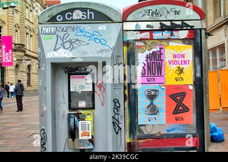 des boîtes d'appel sont parsemées d'affiches de graffiti et vandales. Buchanan Street The style Mile of Glasgow, Écosse, Royaume-Uni Banque D'Images