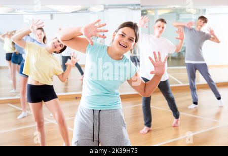 Une adolescente s'exerçant pendant un cours de danse de groupe Banque D'Images