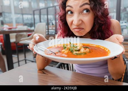 Une femme insatisfaite cliente du restaurant a l'odeur dégoûtante d'un bol de soupe aux ingrédients gâtés et va se plaindre au Banque D'Images