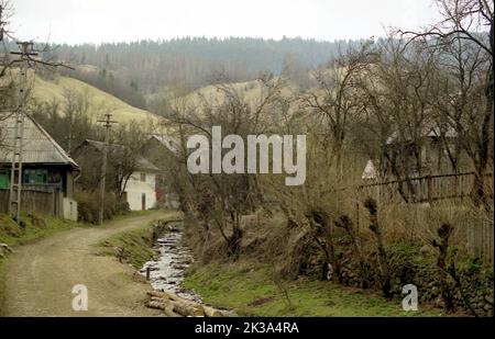 Roșia Montana, Comté d'Alba, Roumanie, env. 1999. Chemin du village par un ruisseau. Banque D'Images