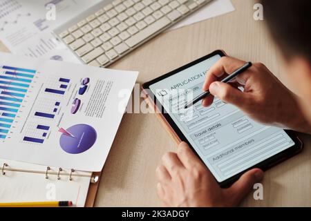 Image rapprochée d'un homme d'affaires qui écrit des données personnelles sous forme d'application sur une tablette numérique Banque D'Images