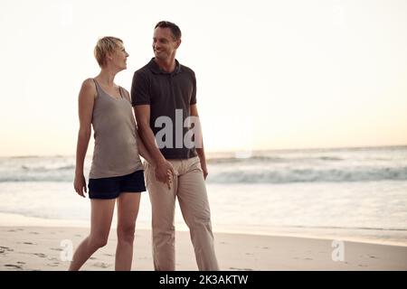 J'adore faire de longues promenades sur la plage. Un couple d'âge mûr fait une promenade sur la plage. Banque D'Images