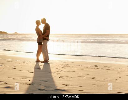 C'est une belle journée pour être amoureux. Un couple mature qui profite d'une journée à la plage. Banque D'Images