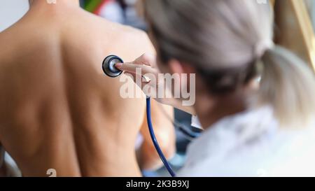 Un jeune médecin examine les poumons du patient avec un stéthoscope Banque D'Images