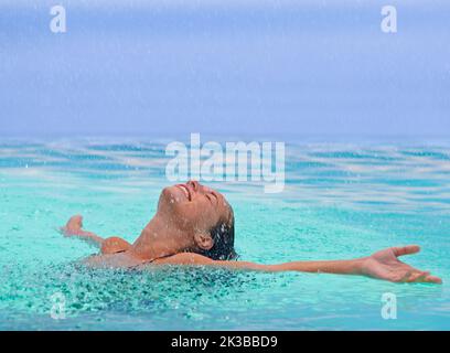 Elle aime être dans l'eau. Une jeune femme qui profite d'une baignade rafraîchissante. Banque D'Images