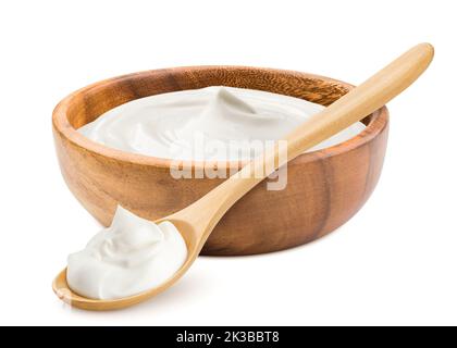 crème aigre dans un bol et une cuillère en bois, mayonnaise, yaourt, isolé sur fond blanc, chemin d'écrêtage, pleine profondeur de champ Banque D'Images