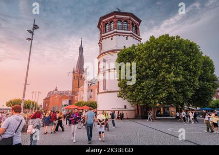 22 juillet 2022, Düsseldorf, Allemagne : personnes marchant sur la promenade et admirant le coucher du soleil sur la vieille ville de Düsseldorf Tours à Altstadt. Voyage et vis Banque D'Images