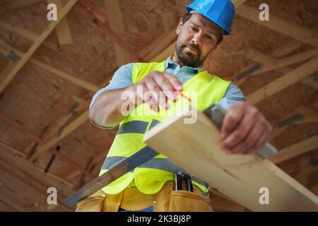 Menuisier mesurant des planches en bois et en faisant des marques avec un crayon, bricolage éco-respectueux des maisons concept. Banque D'Images