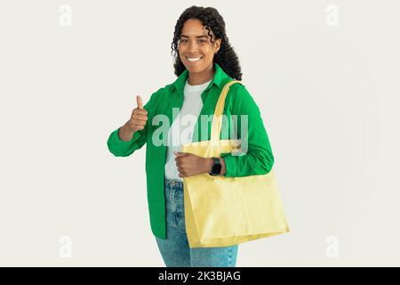 Femme africaine posant avec sac de textile gestante comme, fond blanc Banque D'Images