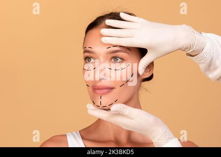 Portrait frontal de la jeune femme obtenant un traitement de spa de l'esthéticienne, chirurgien plastique faisant des marques sur le visage de la femme Banque D'Images