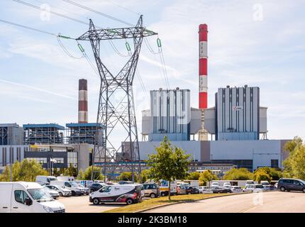 Bâtiment principal de la centrale au charbon EDF de Cordemais près de Nantes, France, avec un pylône électrique et un parking par beau temps d'été. Banque D'Images