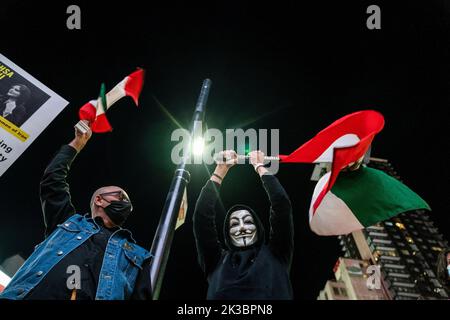 Toronto, Canada. 23rd septembre 2022. Un homme portant un masque Guy Fawkes fait dévier un drapeau iranien au-dessus de sa tête pendant la manifestation. Des centaines de personnes se sont rassemblées pour honorer Mahsa Amini et protester contre le gouvernement iranien à Toronto, au Canada. (Photo de Katherine Cheng/SOPA Images/Sipa USA) crédit: SIPA USA/Alay Live News Banque D'Images