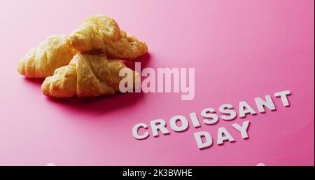 Image de gros plan des croissants et du texte croissant du jour sur fond rose Banque D'Images