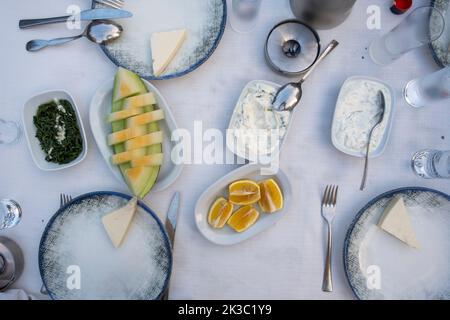 Table de raki turque avec melon, citron et hors-d'œuvre, alcool turc traditionnel connu sous le nom de Rakı, détendez-vous entre amis au restaurant, dîner et idée de repas Banque D'Images