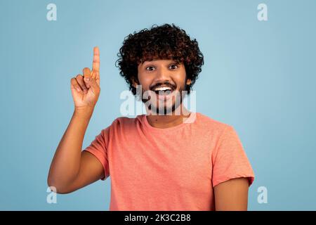 Un homme hindou excité pointant du doigt vers le haut sur le bleu Banque D'Images