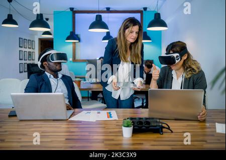 Divers collègues ont l'expérience de la réalité virtuelle pendant leur travail au bureau Banque D'Images
