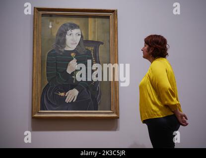 Un membre du personnel de la galerie pose à côté d'un tableau de Lucian Freud - Girl with Roses, 1947-8, l'un des nombreux portraits de la première femme de Freud, l'artiste Kathleen 'Kitty' Garman (1926-2011) - présenté à un photohall pour l'exposition Credit Suisse - Lucian Freud: Nouvelles perspectives à la National Gallery de Londres. Date de la photo: Lundi 26 septembre 2022. Banque D'Images