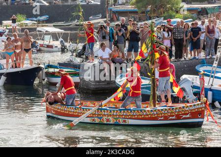 Le festival annuel de 'U Pisci a mari' dans le village sicilien d'ACI Trezza, près de Catane. Cela a lieu autour de la Fête de la Nativité de Saint Jean-Baptiste, à la fin du mois de juin. Il représente une expédition traditionnelle de pêche de l'espadon, qui avait lieu dans le détroit de Messine. La partie de l'espadon est jouée par un nageur, qui est pris à plusieurs reprises par les pêcheurs, sectionné dans le sang, mais parvient d'une manière ou d'une autre à s'échapper. Finalement, l'espadon parvient à renverser le bateau. Banque D'Images