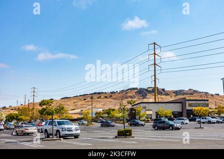 Câbles d'alimentation suspendus maintenus par des pylônes le long d'un parking dans un centre commercial stip de Vallejo, Californie Banque D'Images