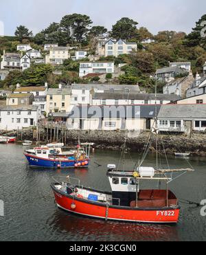 Image en format portrait du port au village de pêcheurs de Polperro, dans le sud des Cornouailles. Vue de l'autre côté du port avec des bateaux de pêche à quai t Banque D'Images