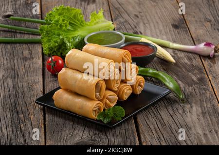 Rouleaux de printemps frits avec sauce Chili douce et citron vert sur l'assiette Banque D'Images