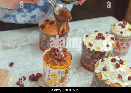 Pâtisserie glacer les gâteaux de Pâques avec du chocolat fondu Banque D'Images