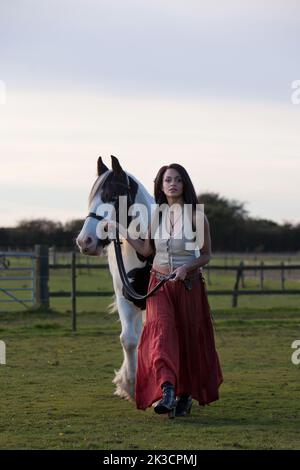 Interprétation d'une fille gitane de 19th ans qui mène son cheval à travers le champ Banque D'Images