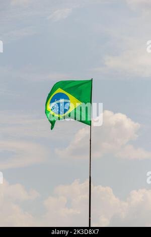 Goias, Brésil – 25 septembre 2022 : drapeau du Brésil volant et flottant dans le vent avec ciel nuageux en arrière-plan. Banque D'Images