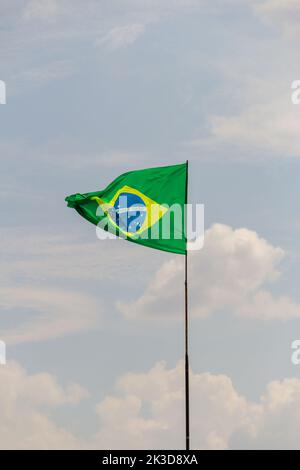 Goias, Brésil – 25 septembre 2022 : drapeau du Brésil volant et flottant dans le vent avec ciel nuageux en arrière-plan. Banque D'Images