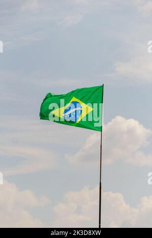 Goias, Brésil – 25 septembre 2022 : drapeau du Brésil volant et flottant dans le vent avec ciel nuageux en arrière-plan. Banque D'Images