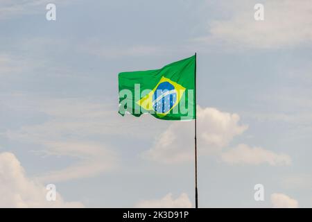 Goias, Brésil – 25 septembre 2022 : drapeau du Brésil volant et flottant dans le vent avec ciel nuageux en arrière-plan. Banque D'Images