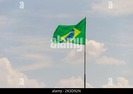 Goias, Brésil – 25 septembre 2022 : drapeau du Brésil volant et flottant dans le vent avec ciel nuageux en arrière-plan. Banque D'Images