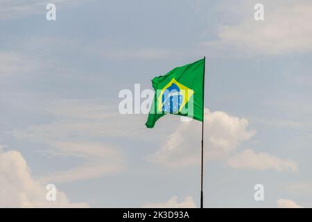 Goias, Brésil – 25 septembre 2022 : drapeau du Brésil volant et flottant dans le vent avec ciel nuageux en arrière-plan. Banque D'Images